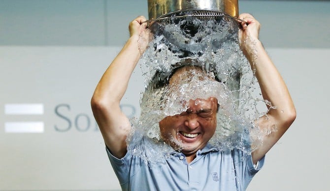 SoftBank Corp. Chief Executive Masayoshi Son dumps a bucket of ice water onto himself as he takes part in the ALS ice bucket challenge at the company headquarters in Tokyo